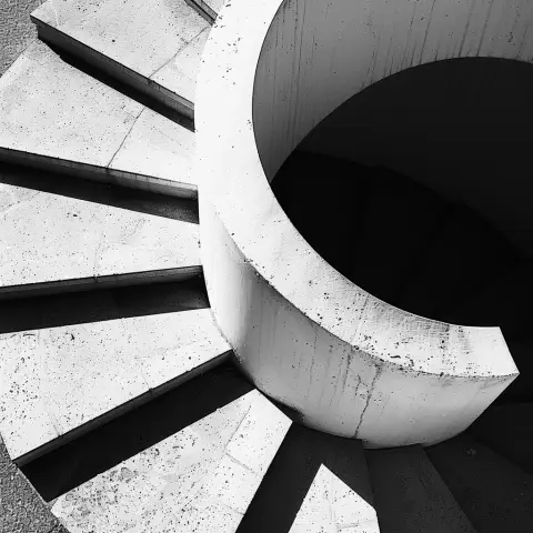 „a photo of a spiral staircase, using its shadow as a graphic element in the composition“