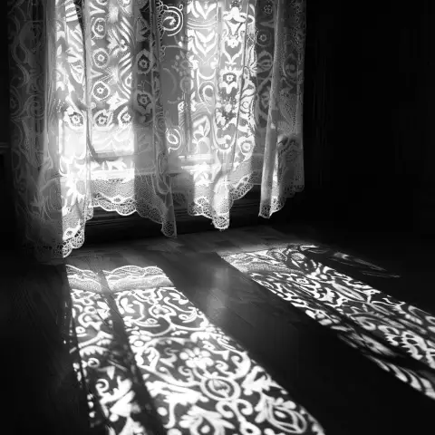 „a photo of light filtering through lace curtains, casting patterned shadows on the floor“